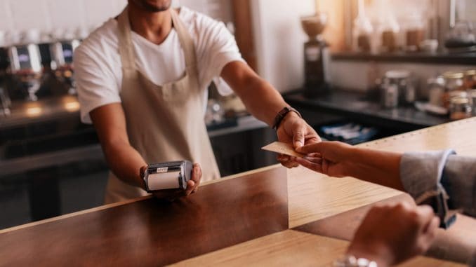 Customer paying through credit card at coffee shop.