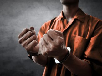 Arrested man in handcuffs in prison
