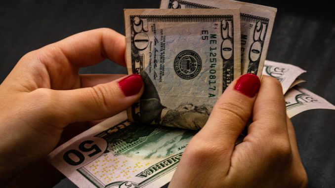 Woman counting money, counting dollars close up.