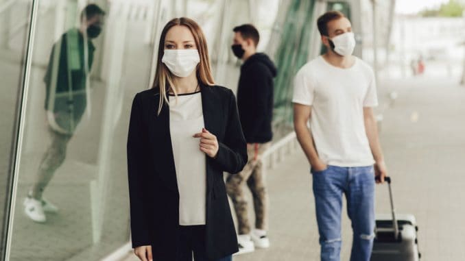 Figures of young people in protective masks near the airport. Safe travel during a pandemic. Airplane travel, quarantine and pandemic concept.