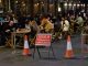 Outdoor street seating at bars and restaurants with COVID-19 Temporary Restrictions sign